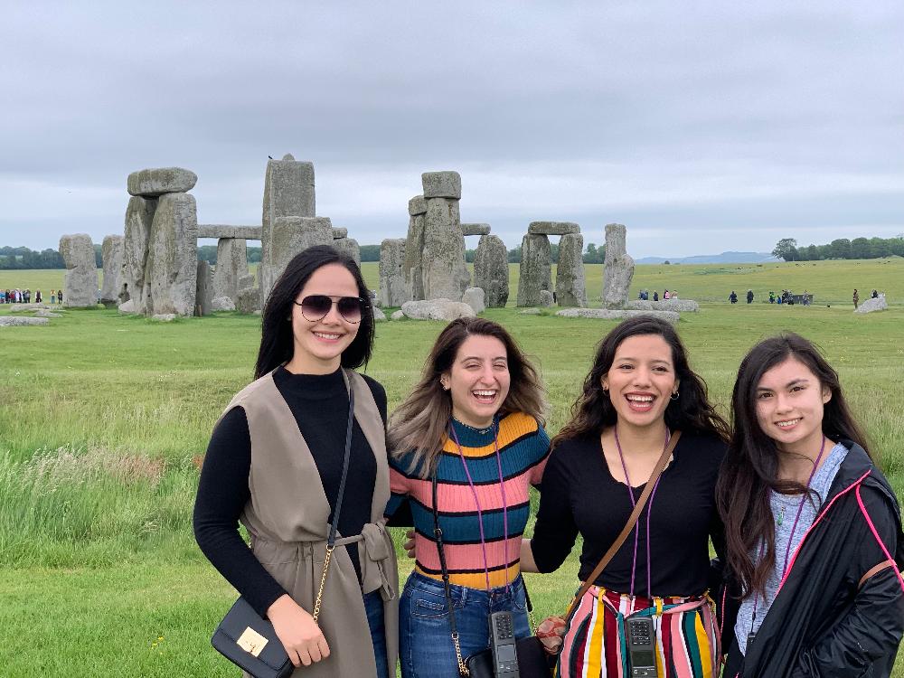 A group of students pose in front of Stonehenge.